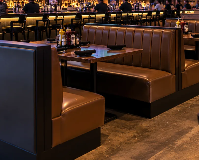 Rows of brown vinyl booths and tables in a sports bar dining area